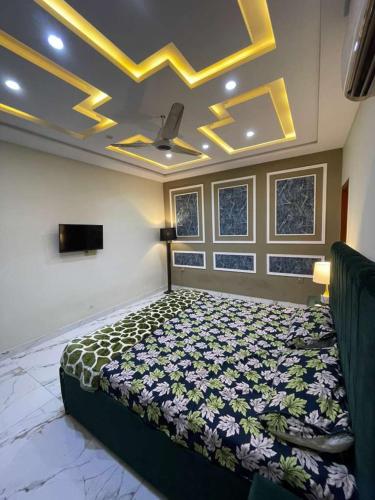 ein Schlafzimmer mit einem Bett in einem Zimmer mit einer Decke in der Unterkunft Modern 1BR Apartment in Multan in Multan