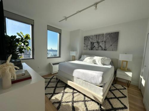 una camera da letto bianca con un letto e due finestre di Time Square Condos a New York