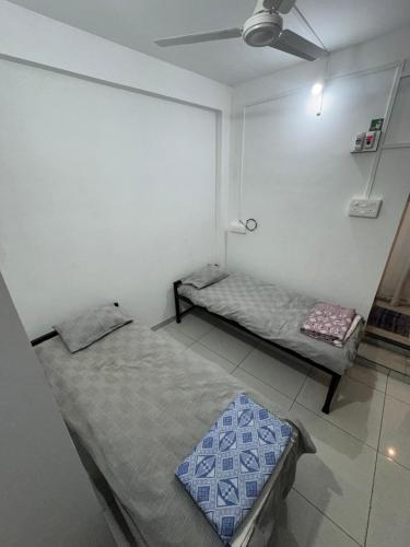 a room with two beds and a ceiling fan at Mahayaatri Niwas in Kolhapur