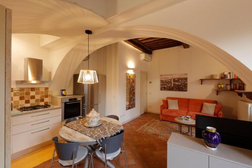 une cuisine et un salon avec une table et un canapé dans l'établissement Siena UpTown - Sabrina's Lovely Apartment, à Sienne
