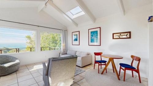 een woonkamer met een bank, een tafel en stoelen bij Perched on the Bluff - Casita in Mendocino