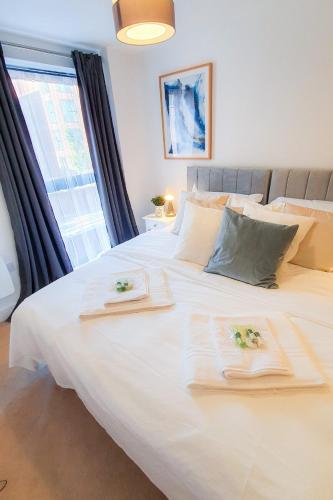 a bedroom with a white bed with two towels on it at Lovely Flat in Kiln Close with Free Parking in Gloucestershire