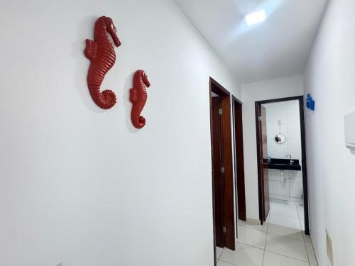 a bathroom with two seahorses hanging on the wall at Apê aconchegante perto do mar in Cabedelo