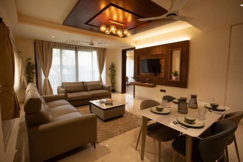 ein Wohnzimmer mit Sofa und Tisch in der Unterkunft Rosse Dale Suites and Hotel Coimbatore in Coimbatore