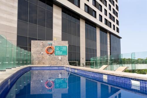 una piscina di fronte a un edificio di Fiesta Inn Mérida Altabrisa a Mérida