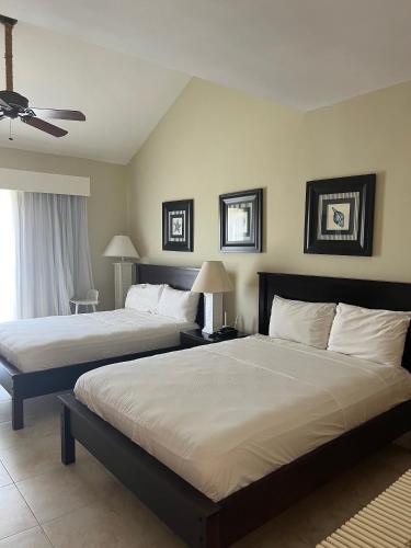 a bedroom with two beds and a ceiling fan at Apartment in Cadaques Caribe in Bayahibe