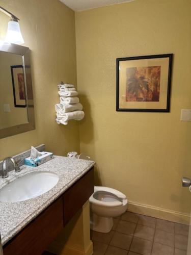 une salle de bains avec lavabo, toilettes et miroir dans l'établissement Brookings Inn, à Brookings