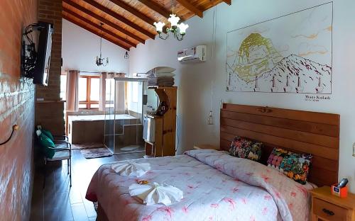 een slaapkamer met een groot bed in een kamer bij Chalés Colline Verte in Monte Verde