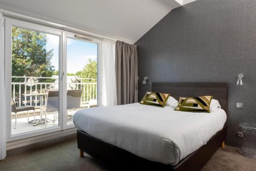 ein Schlafzimmer mit einem großen Bett und einem Balkon in der Unterkunft Best Western Hotel Acadie Paris Nord Villepinte in Tremblay En France