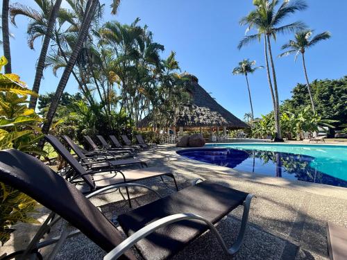 a group of chairs next to a swimming pool at Premium Glamping - Pool Waterslide Wi-Fi & Private Patio Lounge in Puerto Vallarta
