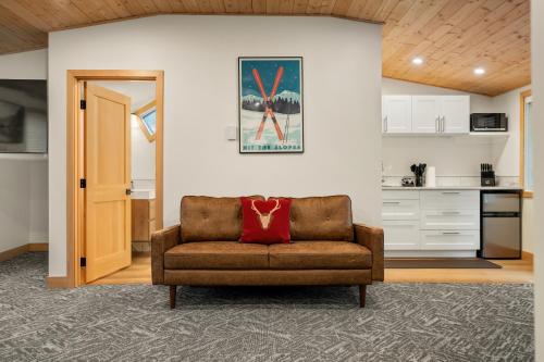 a living room with a couch and a kitchen at Elkhorn Lodge Vacation Rentals in Banff