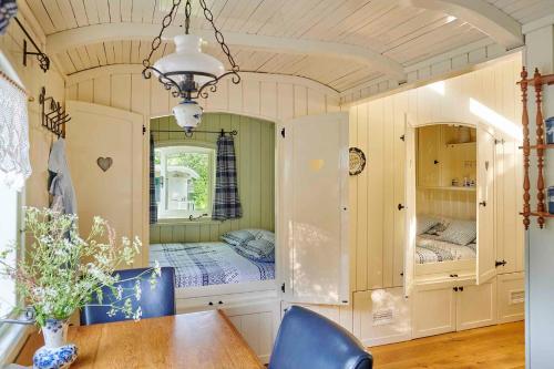 a bedroom with two beds and a table and chairs at Pipowagen de Luxe, prive hottub en zwembad in Heythuysen