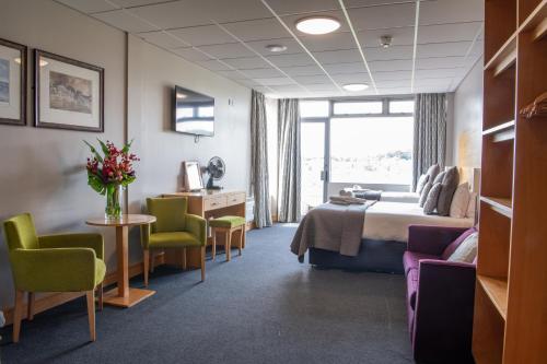 a hotel room with a bed and a table and chairs at Headingley Stadium Hotel in Leeds