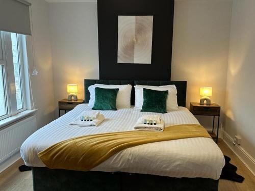 a bedroom with a large bed with two towels on it at 3 bed Chill Glouc Free Parking in Gloucester