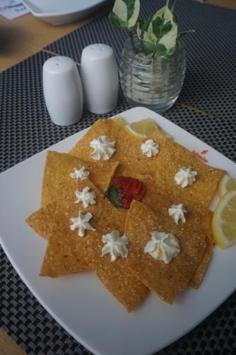 a white plate topped with nachos on a table at Unisi Hotel Malioboro - Jogja Syariah in Yogyakarta