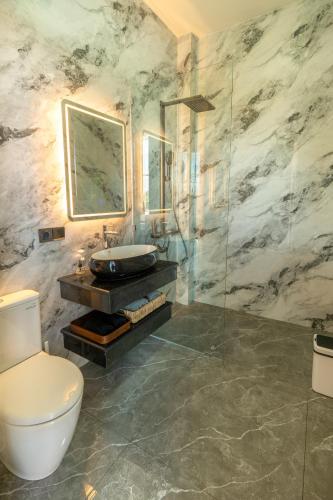 a bathroom with a toilet and a sink and a shower at Shukty Villa Pandawa in Ungasan