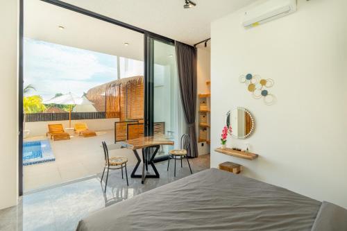 a bedroom with a bed and a balcony at Shukty Villa Pandawa in Ungasan