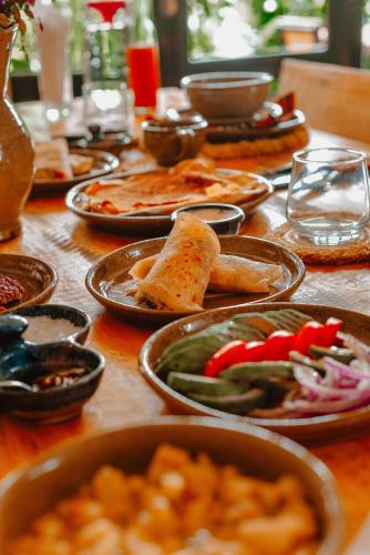 KinigiKinigi Cottage的一张木桌，上面摆放着食物盘子