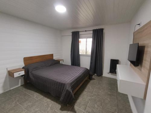 una camera da letto con un letto e una televisione di LA VENTURA, Azul ad Azul