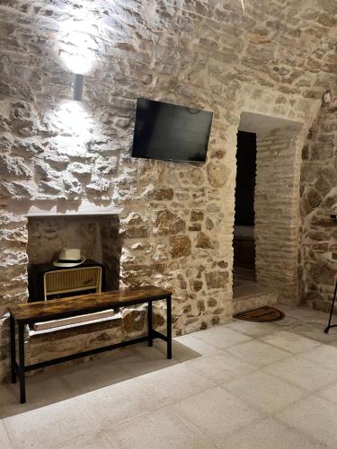 een stenen kamer met een tv aan een stenen muur bij Laura stone room in Corato