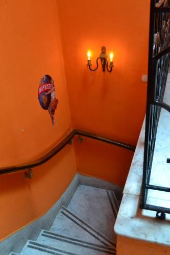 an orange room with a staircase with a hat on the wall at Pin-up hostel in Rosario