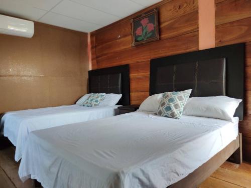 two beds in a room with wood paneling at Casa Playa Linda VILLA LUA Tapachula in El Desengaño