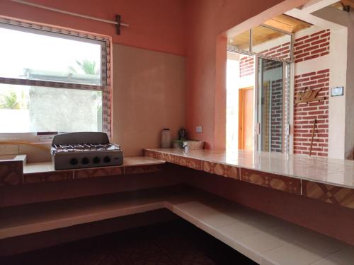 a kitchen with a counter top and a window at Casa Playa Linda VILLA LUA Tapachula in El Desengaño