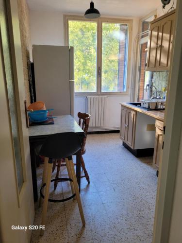een keuken met een tafel en een koelkast bij Mat68 in Nîmes