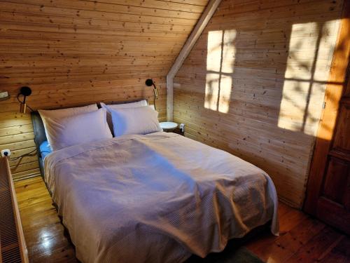 a bedroom with a large bed in a wooden wall at Colorful Life by STN in Balatonudvari