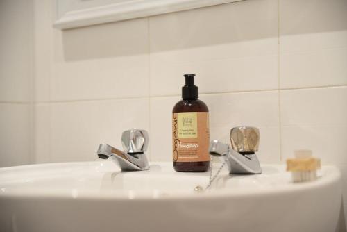 een fles zeep bovenop een wastafel bij Govandale Seaviews in Kingarth