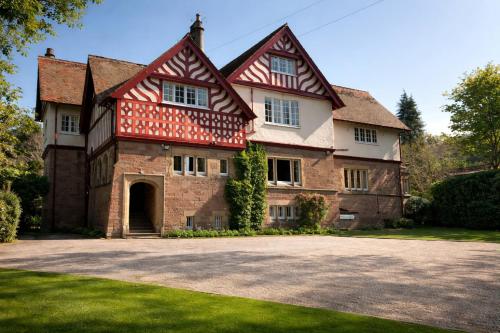 een groot bakstenen huis met een rood dak bij Rossal House Apartments, Inverness, Highlands in Inverness