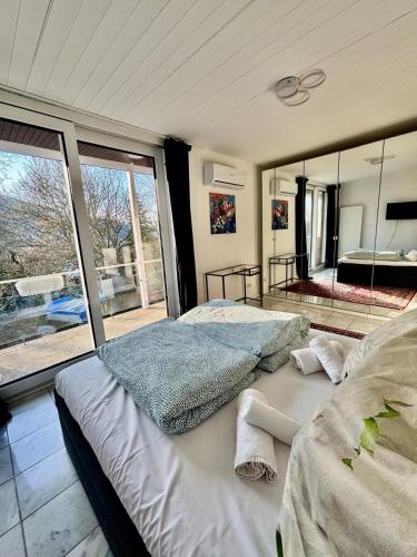 ein Schlafzimmer mit einem großen Bett und einem großen Fenster in der Unterkunft Villa Plesse - exklusiv und geräumig wohnen nahe Göttingen in Bovenden