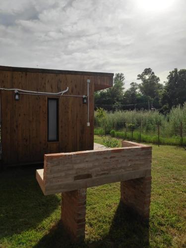 a wooden building with a bench in a field at Cabañas Natural Box 2 in Victoria