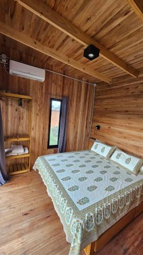a bedroom with a bed in a wooden room at Cabañas Natural Box 2 in Victoria