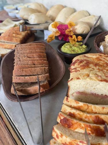 a table topped with different types of cakes and bread at Pousada Lumawê Caraíva in Caraíva