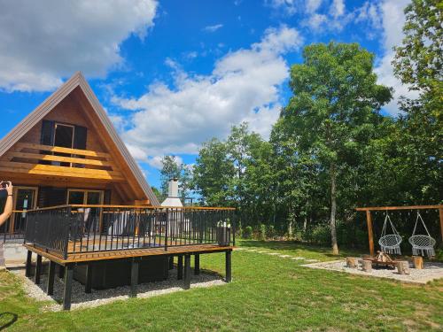 a log cabin with a deck and a house at Tomina Koliba Lika in Sveti Rok