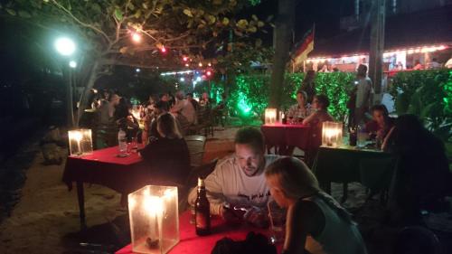 a group of people sitting at a restaurant at night at Dilena Beach Inn in Tangalle