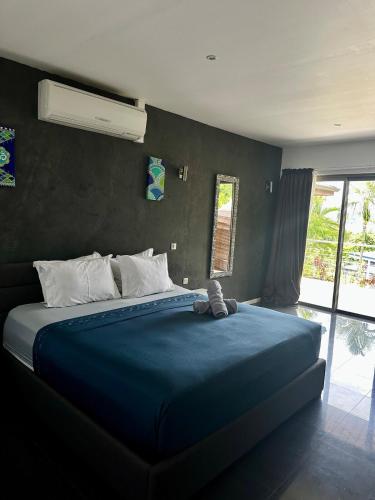 a bedroom with a large bed with a blue blanket at Villa Alana in Bora Bora