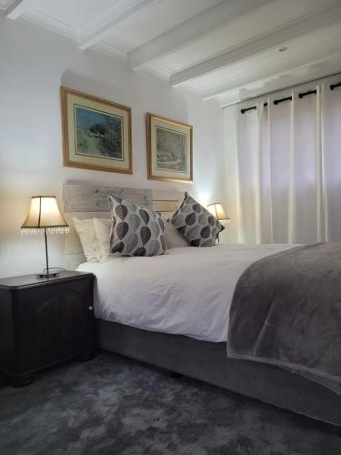 a bedroom with a large bed with two pillows at Lionsgate Estate Cottage in Dargle