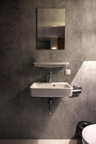 a bathroom with a white sink and a mirror at Shelter City Christian Hostel in Amsterdam