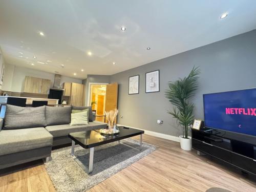 a living room with a couch and a tv at Modern TWO Bedroom Apartment Birmingham City Centre - 2 BATHROOMS - SLEEPS 6 GUESTS - FREE Underground Parking - FAST Speed Internet in Birmingham