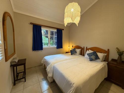 En eller flere senge i et værelse på Esigodini Cottage