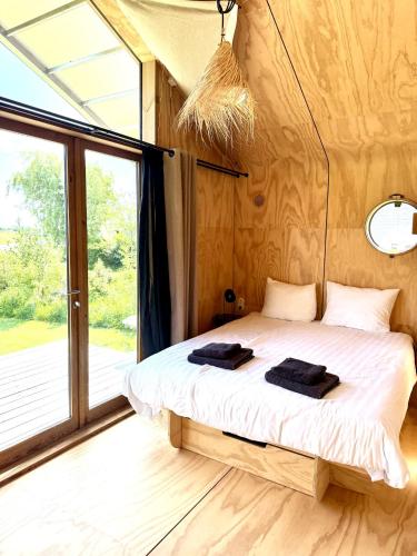 a bed in a room with a large window at Lakehouses luxe family holiday house 6 pers in Oud-Ade