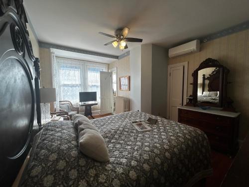 ein Schlafzimmer mit einem Bett, einer Kommode und einem Spiegel in der Unterkunft Beauclaires Bed & Breakfast in Cape May