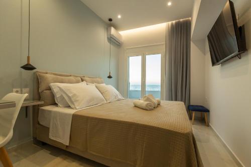 ein Schlafzimmer mit einem Bett und einem Fenster in der Unterkunft On The Waves Suites in Korinthos