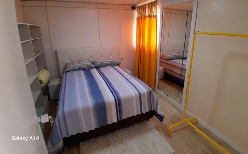 ein Schlafzimmer mit einem Bett in einem Zimmer mit einem Spiegel in der Unterkunft Casa Completa Charmosa e Perfeita para Você in Caxias do Sul