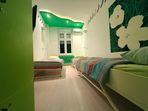 een kamer met twee bedden en een groen plafond bij Pop Art in Belgrado