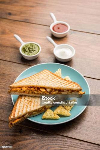 een bord met een sandwich, friet en saus bij Snower Valley homestay in Kulu