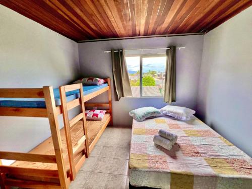 ein Schlafzimmer mit zwei Etagenbetten und einem Fenster in der Unterkunft #PéNaAreia em Matinhos Beach in Matinhos
