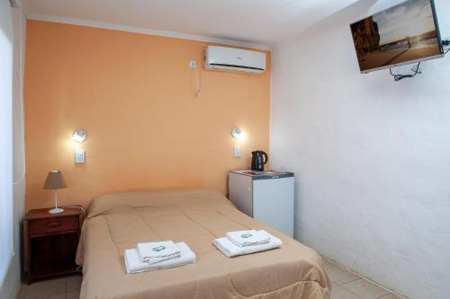 een slaapkamer met een bed met twee handdoeken erop bij Desert Tracks Rancho in Las Grutas